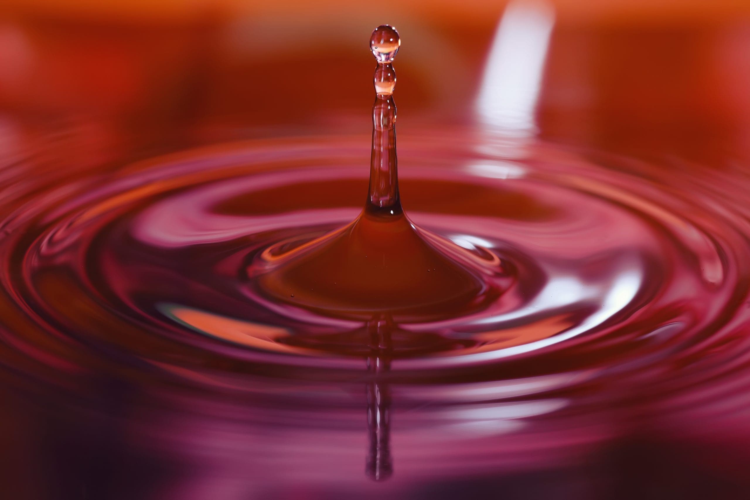 Macro Photo Of Water Drops Falling Into A Pool Of Water