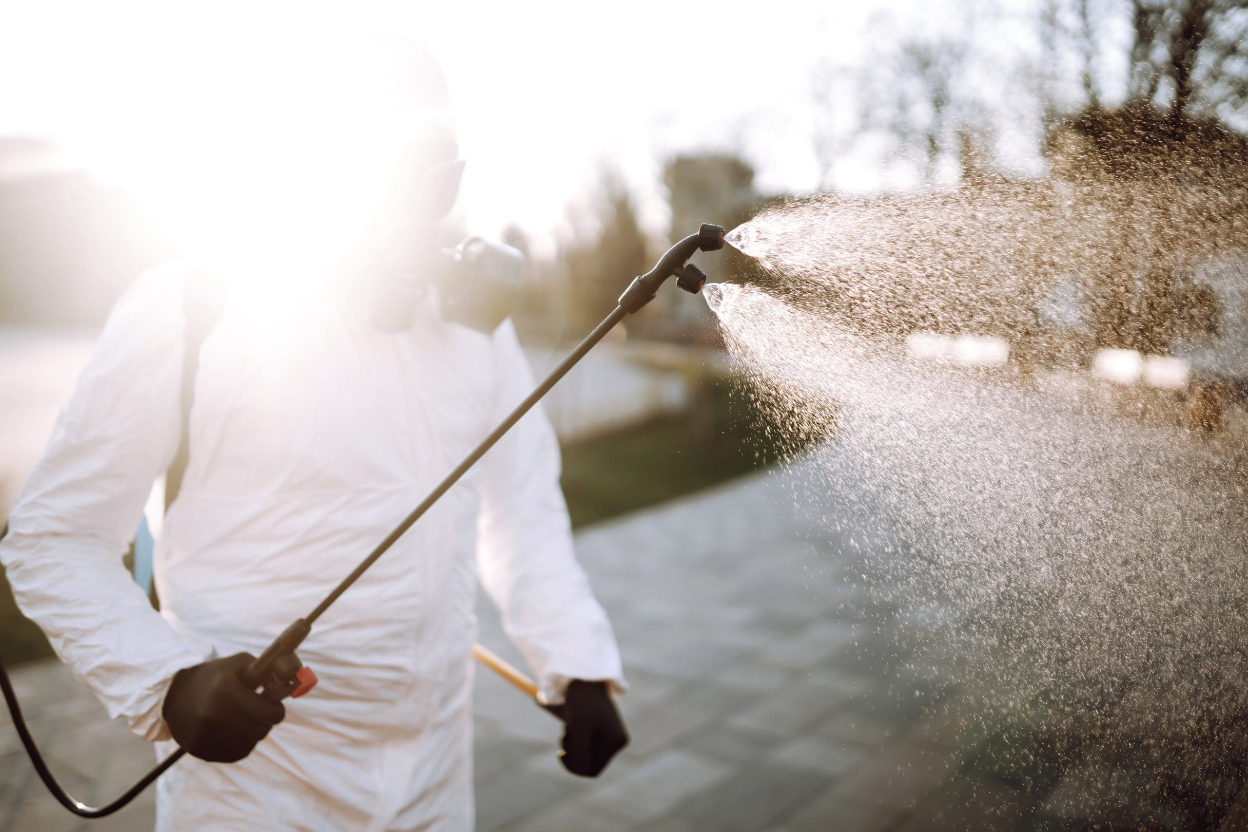 Man In Virus Protective Suit And Mask Disinfects Public Places. Infection Prevention And Control.