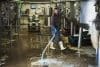 Man Working In A Brewery, Cleaning Floor With Water Hose.,renegade Brewery,england
