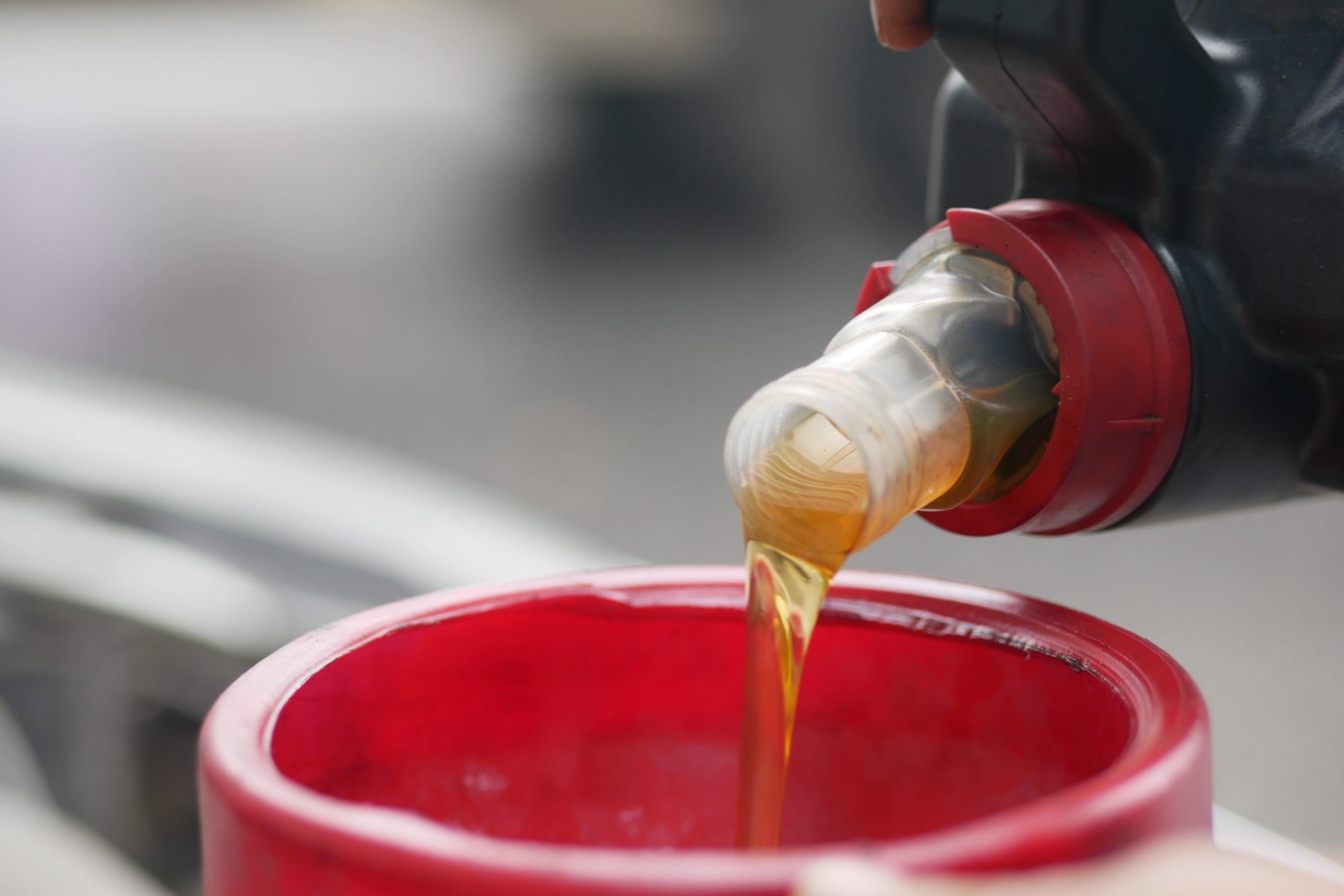 Pouring Liquid Into Red Funnel For Engine Maintenance