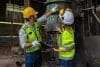 Two Engineers In A Steel Mill Consult The Size Of The Steel Work