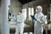 Two Female Supervisor In Hazmats Using Tablet Monitoring Fermentation In Tanks Indoors