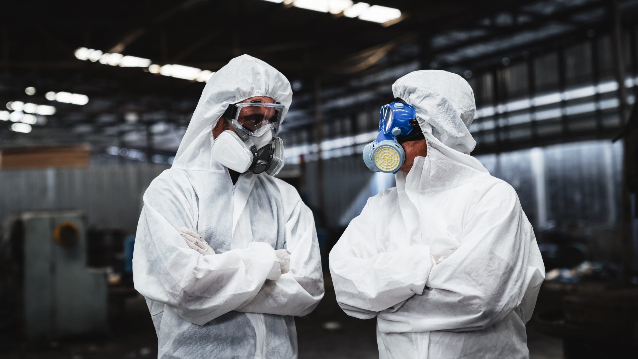 Workers In Safety Suits Check Chemicals In An Old Factory During A Radiation Emergency.